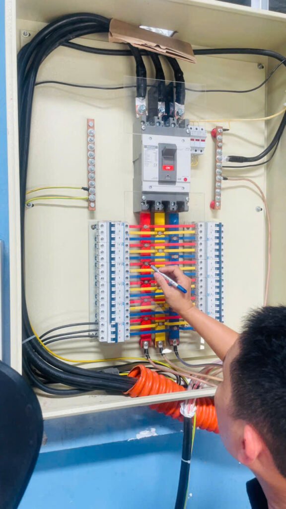 Kỹ thuật viên đấu dây điều khiển trong tủ điện công nghiệp