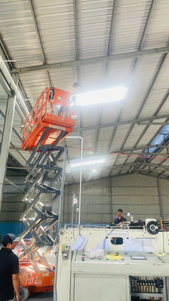 Xe nâng người làm việc trên cao trong nhà xưởng